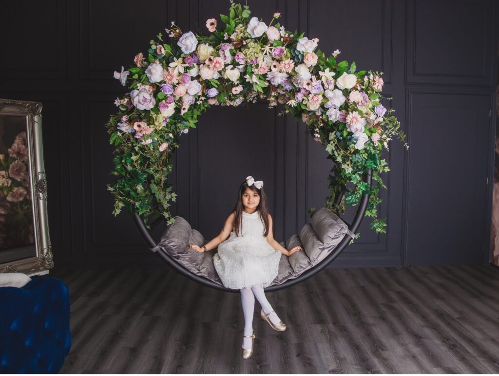 girl sitting on a floral swing